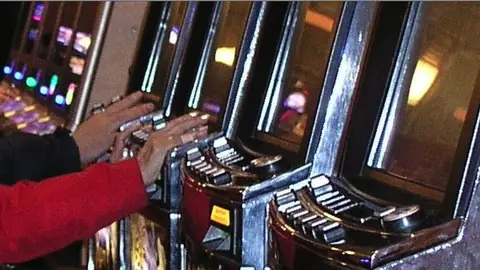 Rad med gamle myntautomater i en halvmørk, tom gang