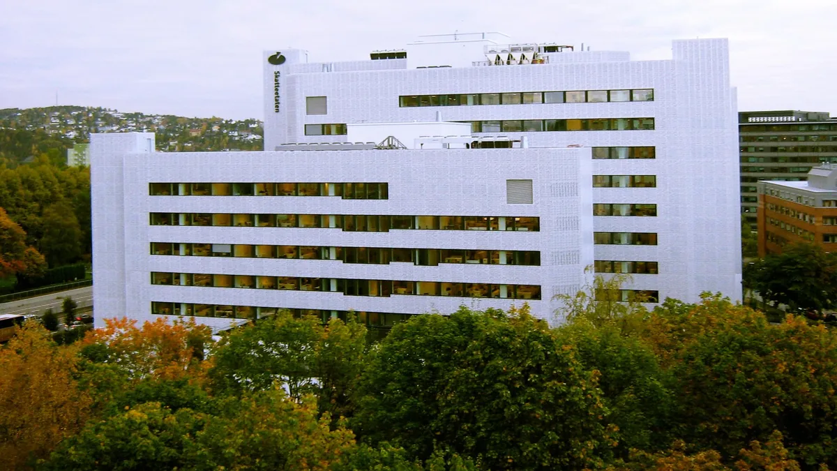 Kalkulator og en stabel sjetonger ved siden av en kvittering på et mørkt trebord